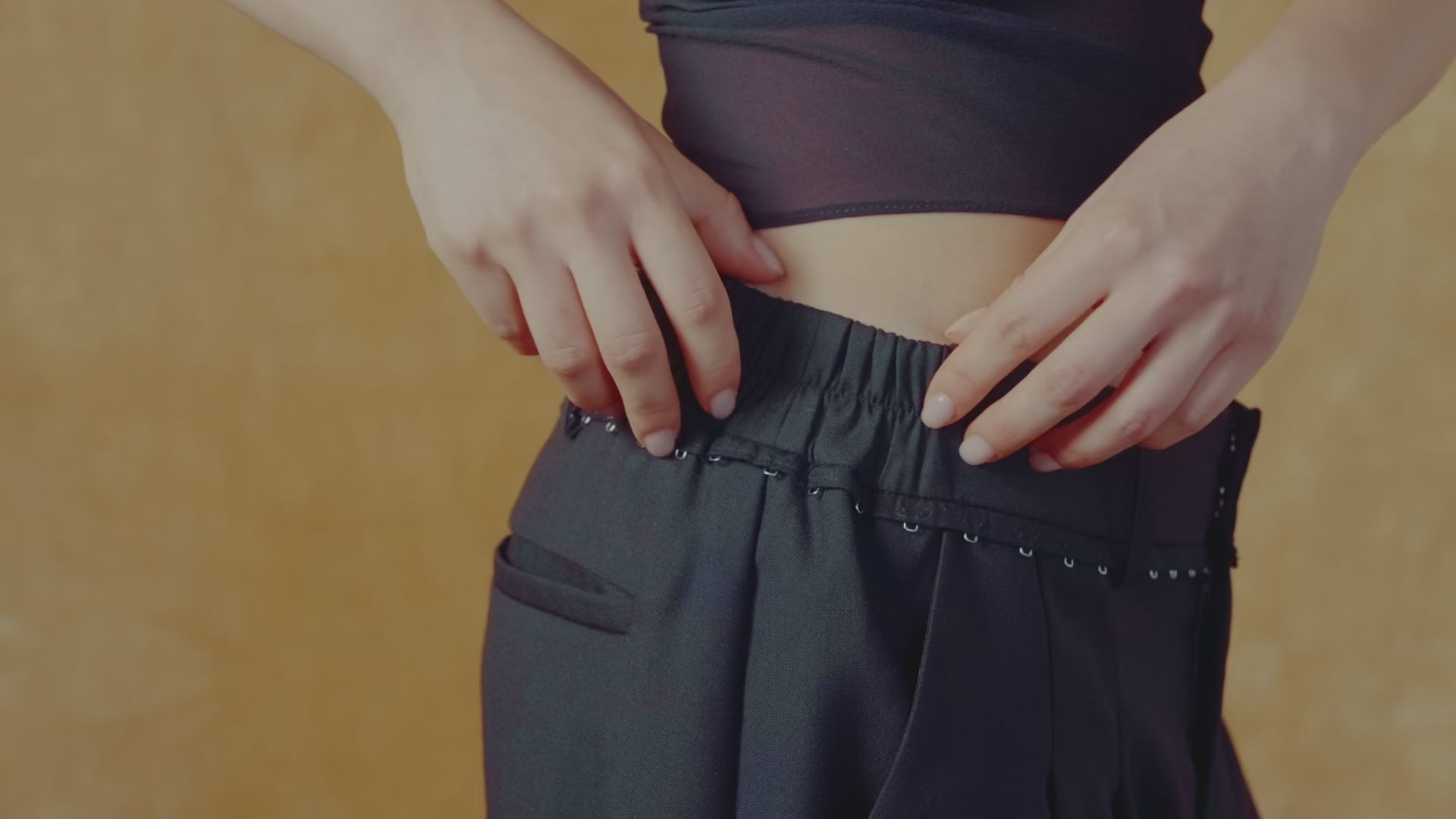 Video showing elasticated waistband, pockets, and hook and eye along the waistband
